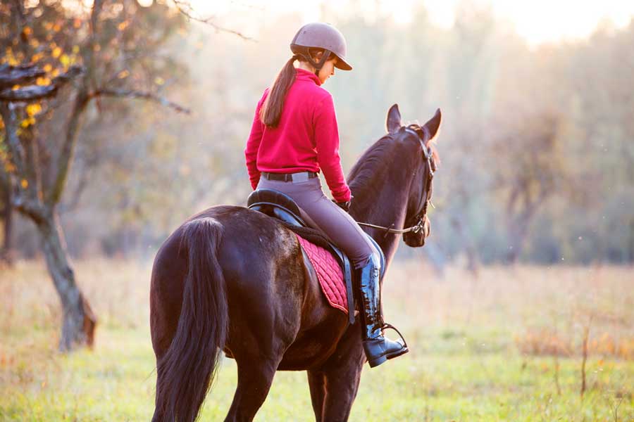 A girl riding a horse in Beaver Meadows Stables