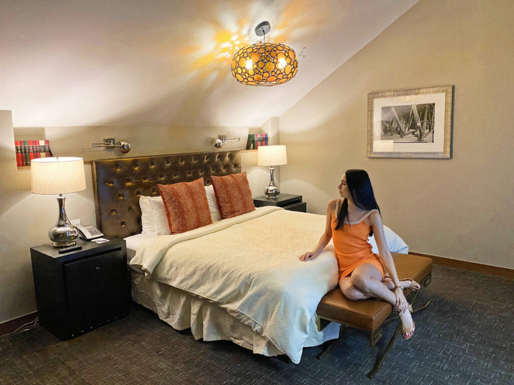 Clara Kesseler sitting on a bed in one of the rooms in The Crawford in Denver