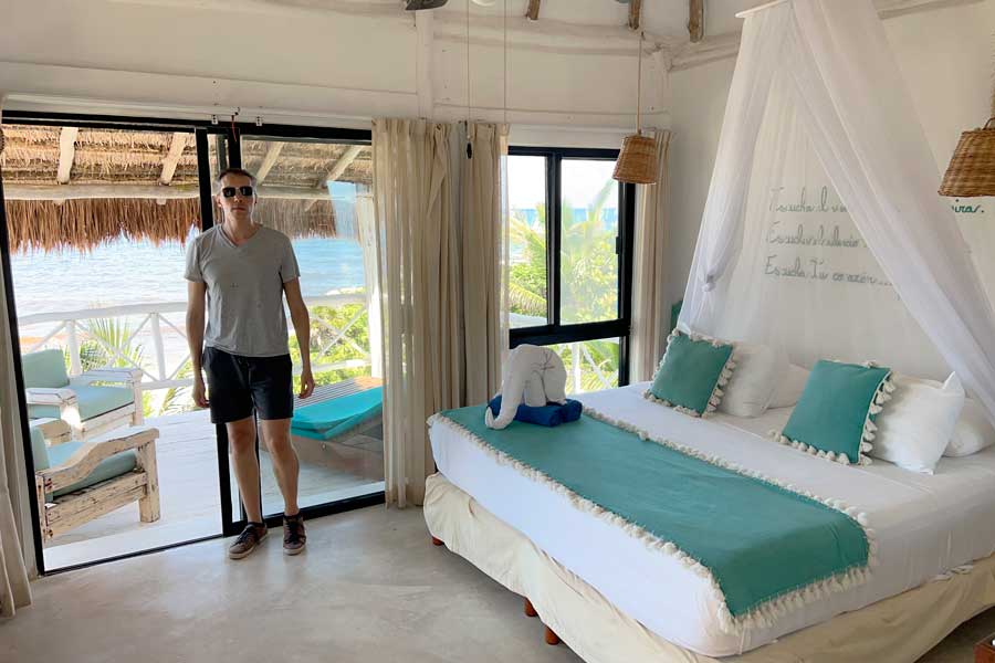 Nate standing beside a bedroom's door going to the balcony