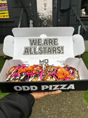 A beef adobo pizza on a box