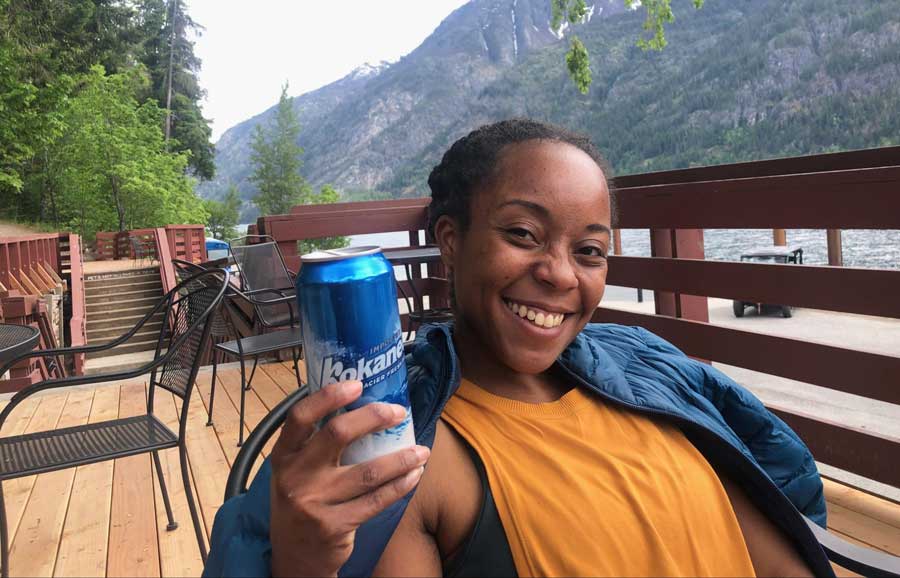 The author posing for a photo while holding a canned beer in Stehekin