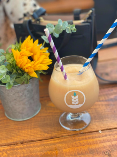 A glass of Beer slushie beside a flower decoration at Pure Project