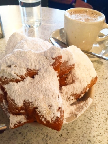 Closeup view of beignets and a cup of coffee from Cafe du Monde