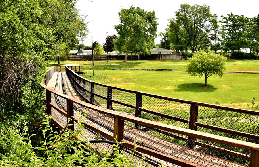View of a foot walk, trees, and a grass field in Belleview Park