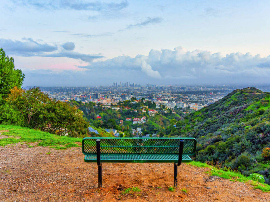 A green bench facing the overlooking view at Runyon Canyon