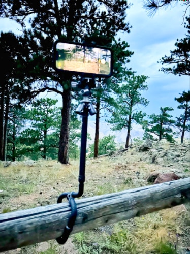 A cellphone mounted on the Benro Tablepod Flex Tripod while it is wrapped on a wooden fence