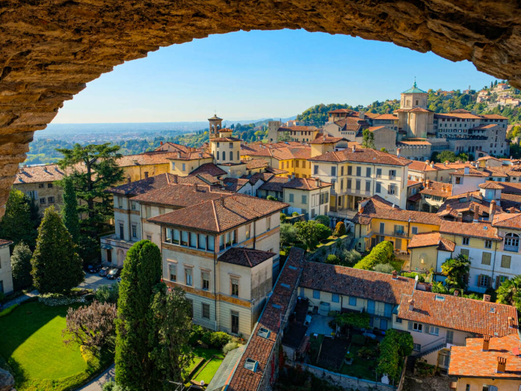 View of houses through a stone archway in Bergamo