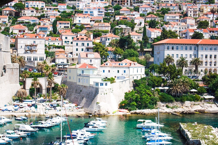 The Dubrovnik harbor in Croatia with sailboats, yachts, and houses in the background