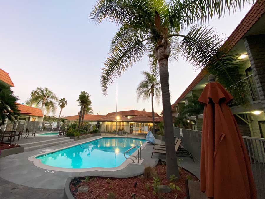 View of a pool and palm trees in Best Western Oceanside Inn