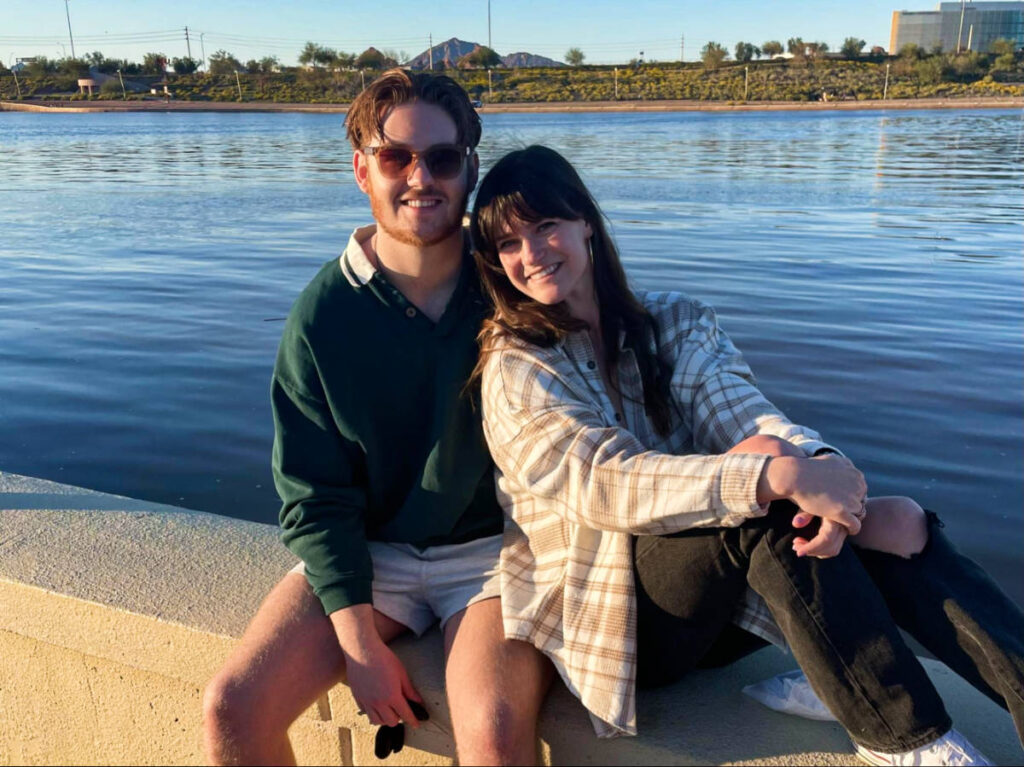 The author Betty Hurd and her boyfriend, posing for a photo with the Tempe Town Lake in the background