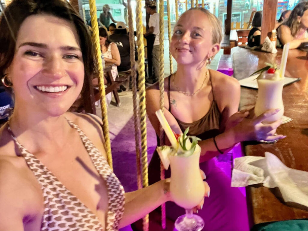 The author Betty Hurd and her friend drinking cocktails at a bar at night