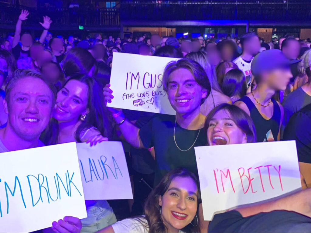 The author Betty Hurd and her friends holding their signs on a concert at The Van Buren