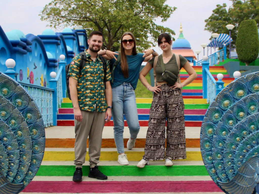 Betty and friends standing at a colorful stairs in India