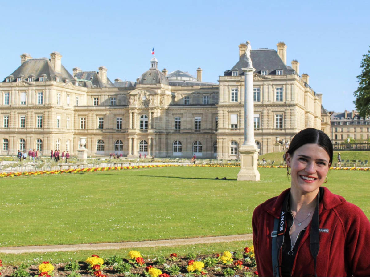 Travel Lemming writer Betty Hurd smiling for a photo in front of the Luxembourg Palace