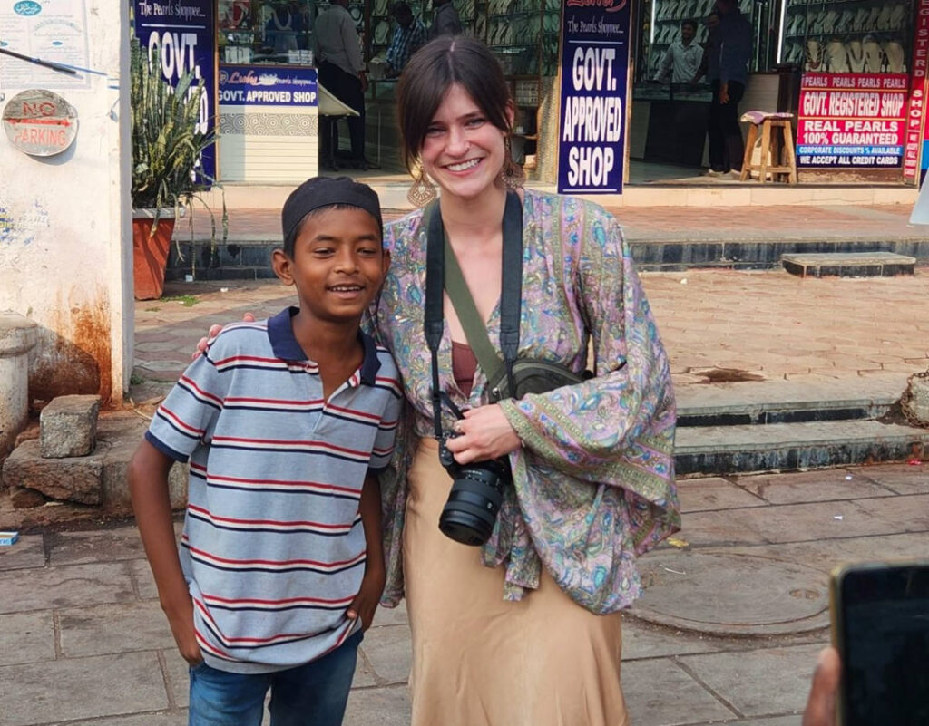 Betty taking a photo with a kid in India