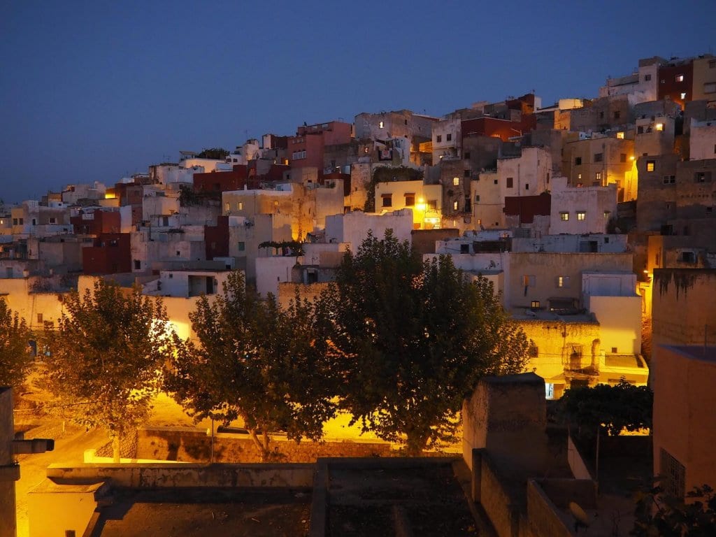 View of houses with lights at night in Bhalil