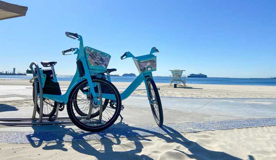 View of two bicycles parked in Long Beach and the clear blue sky over it