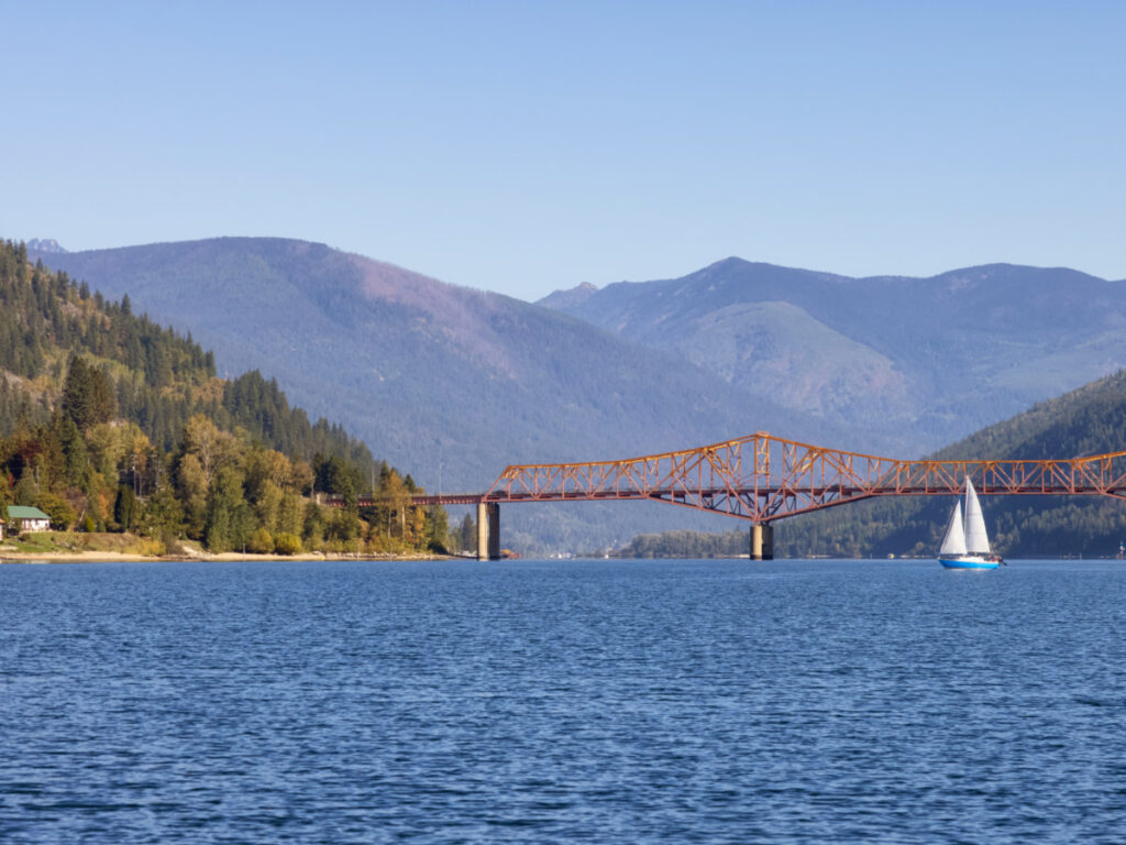 Scenic View of Big Orange Bridge and Kootenay River with Sailboat