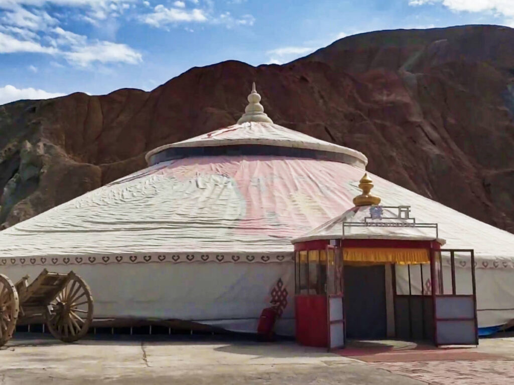 Panoramic view of the big yurt with the rainbow mountains in the background