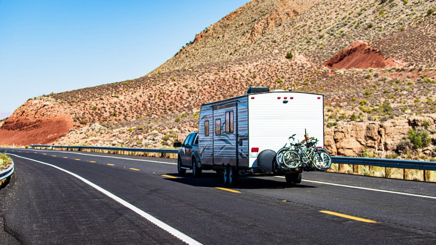 Camper Van with bicycle racks at the back on the road in Mohave desert