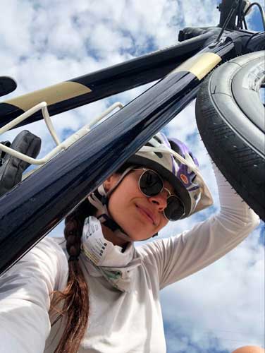 The author smiling for a selfie while carrying her bike
