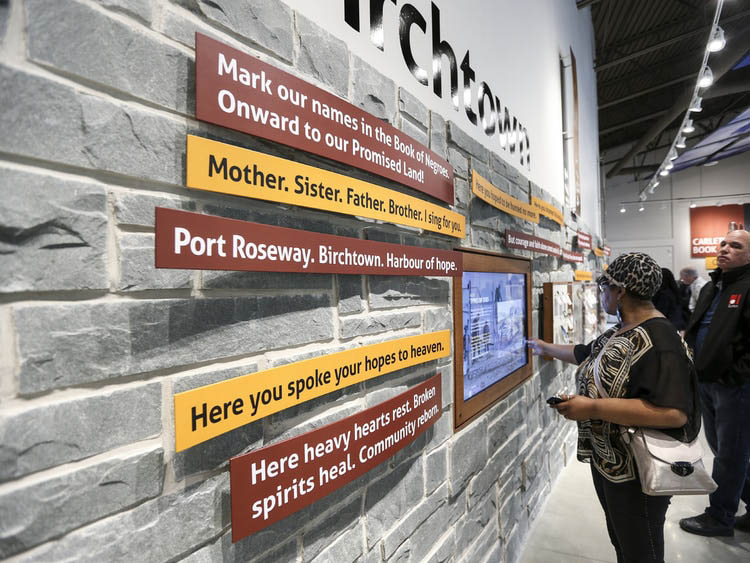 People looking at exhibit on the wall at Birchtown Black Loyalist Centre in Shelburne, Nova Scotia