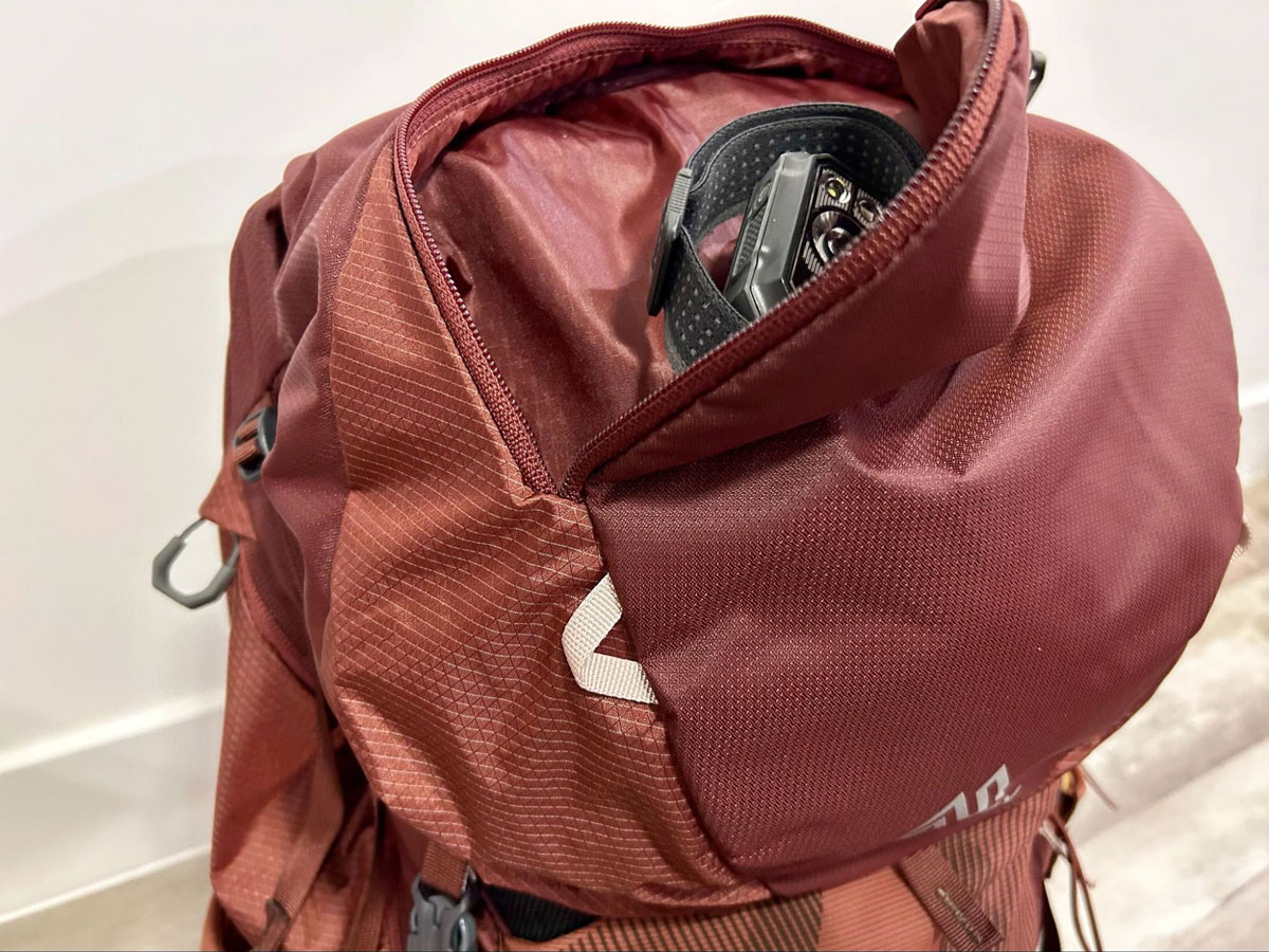 A black diamond headlamp on the removable lid of the Gregory Maven backpack