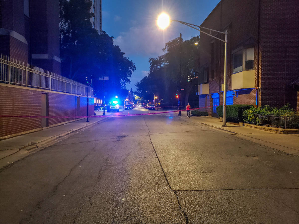 View of a street at night blocked off by the Chicago Police Department