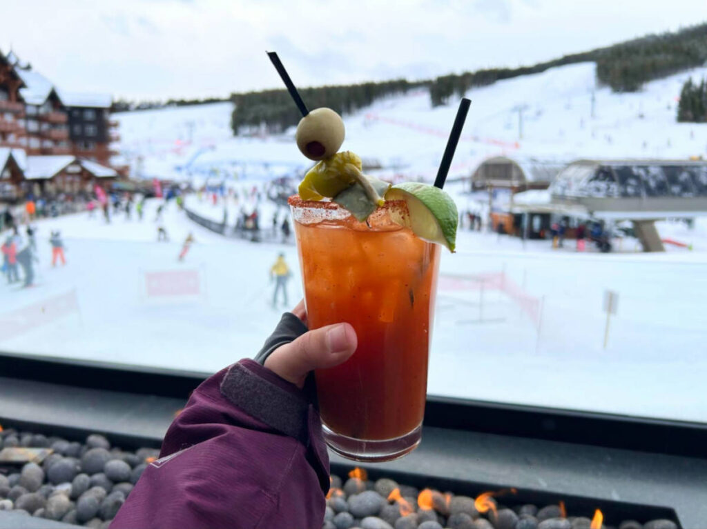 A glass of bloody Mary with the ski resort view behind