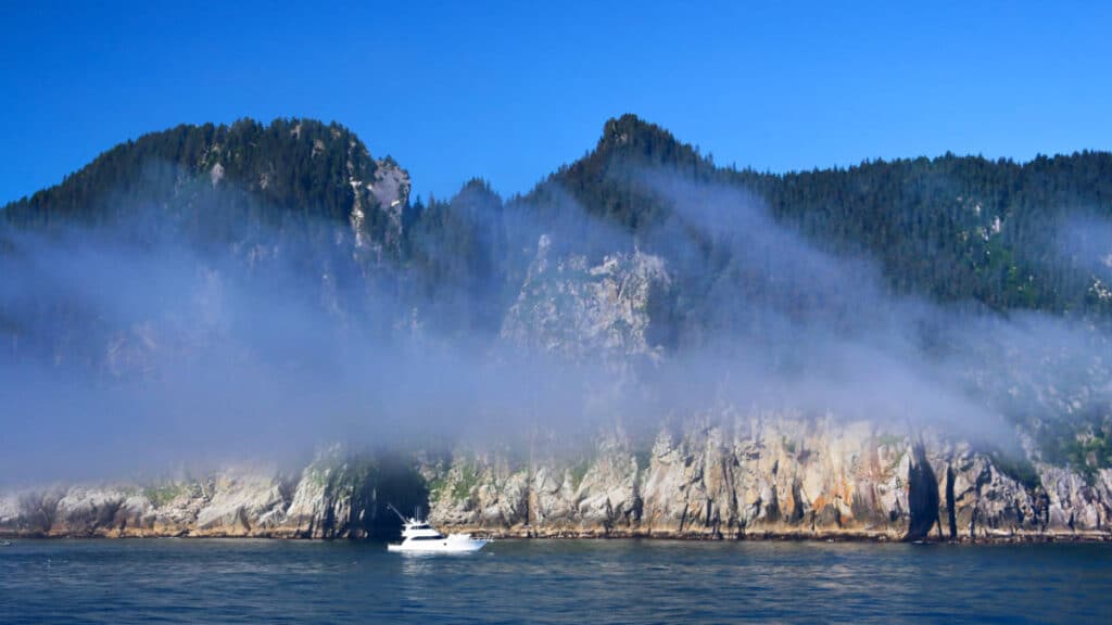 A boat sailing at the foggy Kenai Fjords
