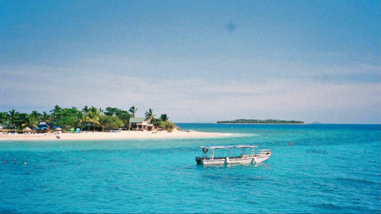A boat docked in front of the island in the Yasawa island chain