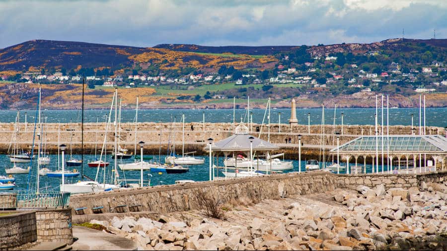 View of the boats docked at the Dun Laoghaire Pier with mountain views in the background