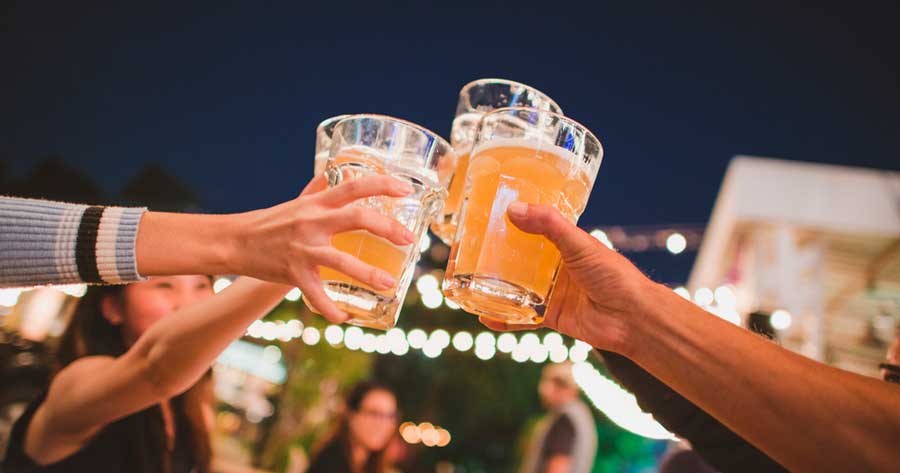 A group of friends clinking their glasses of beer