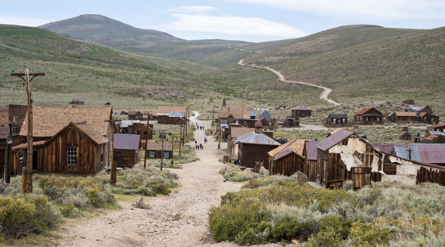 Iconic houses and structures in Bodie State Historic Park with a scenic view in the background