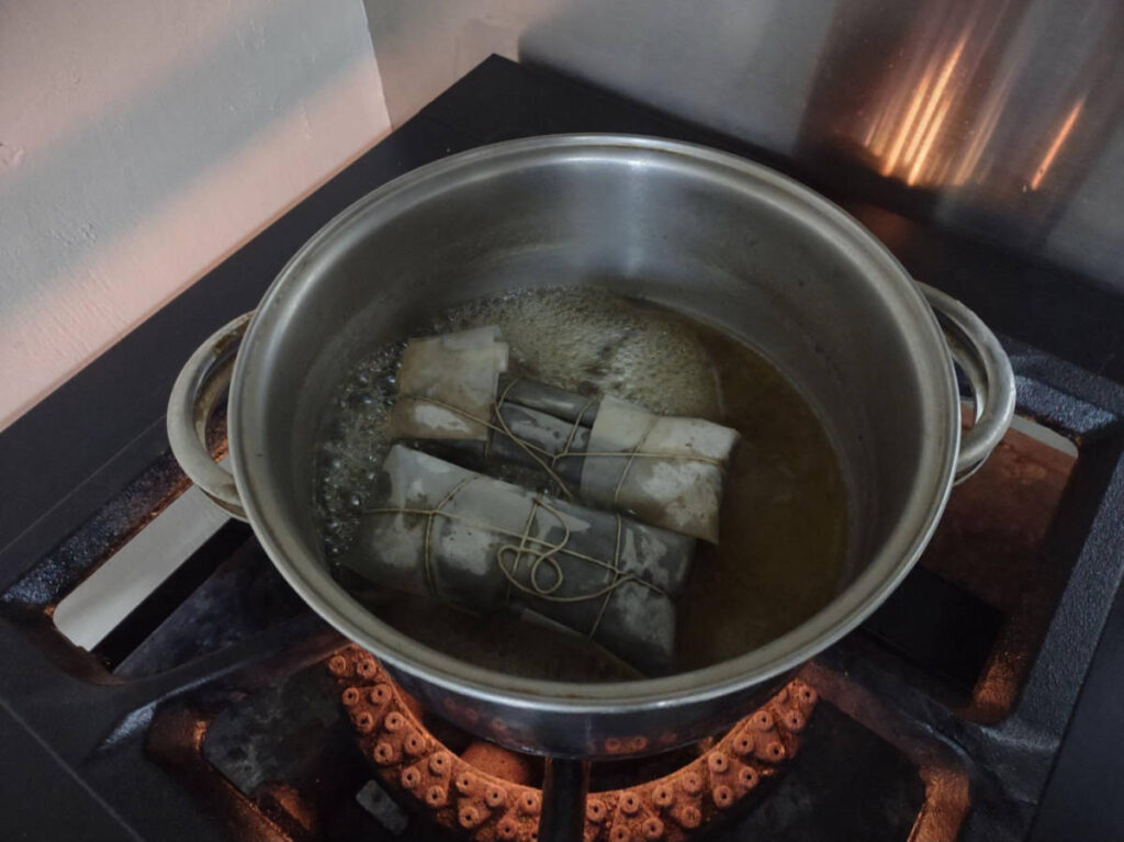 The pasteles in the pan with boiling water