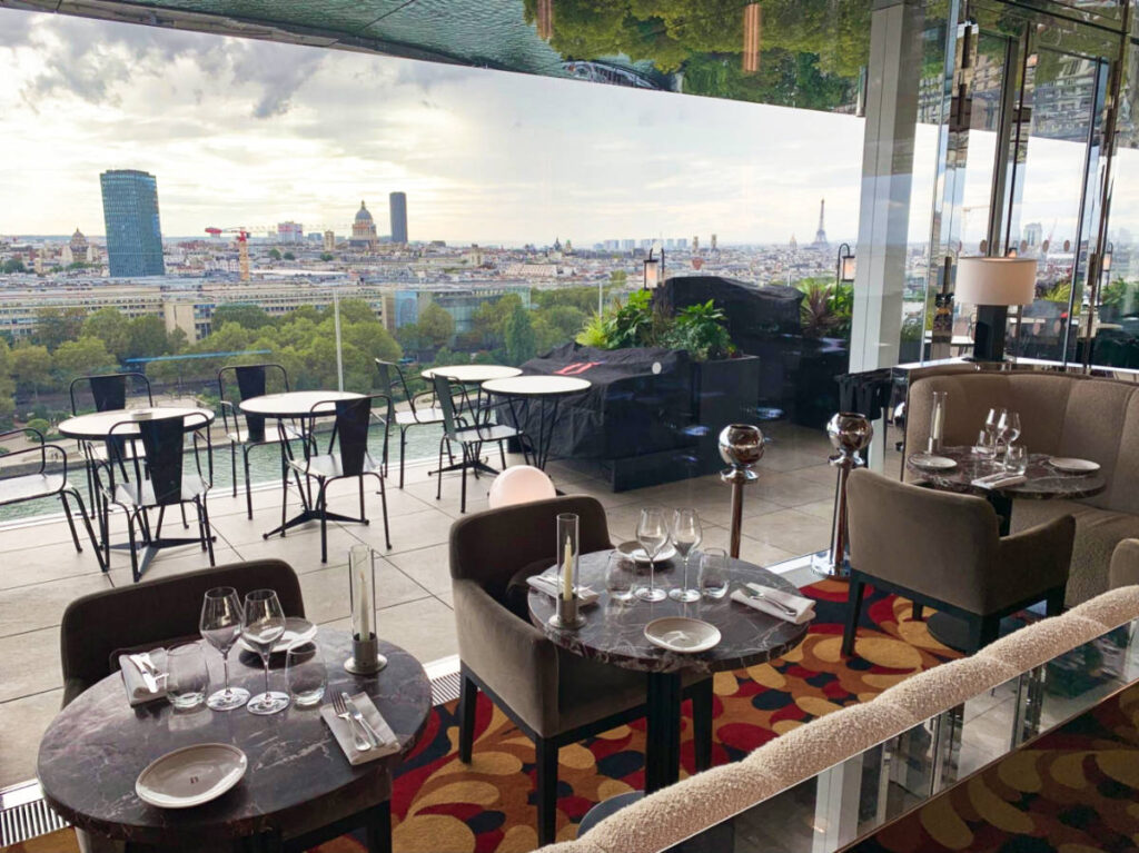 View of the interior of Bonnie's with a floor to ceiling glass window overlooking the cityscape