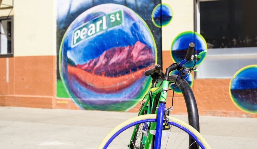 View of a bicycle and a colorful street mural behind it