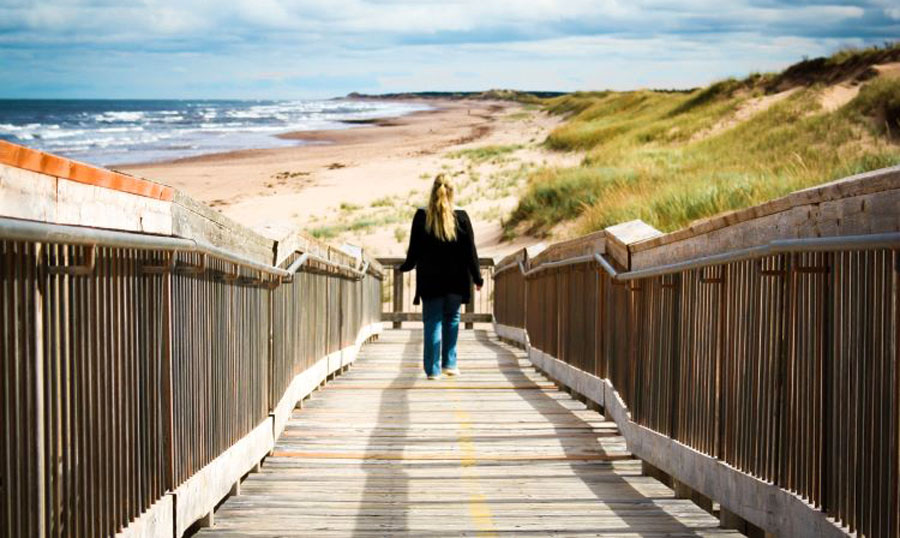 The author walking on a boardwalk going to the beach