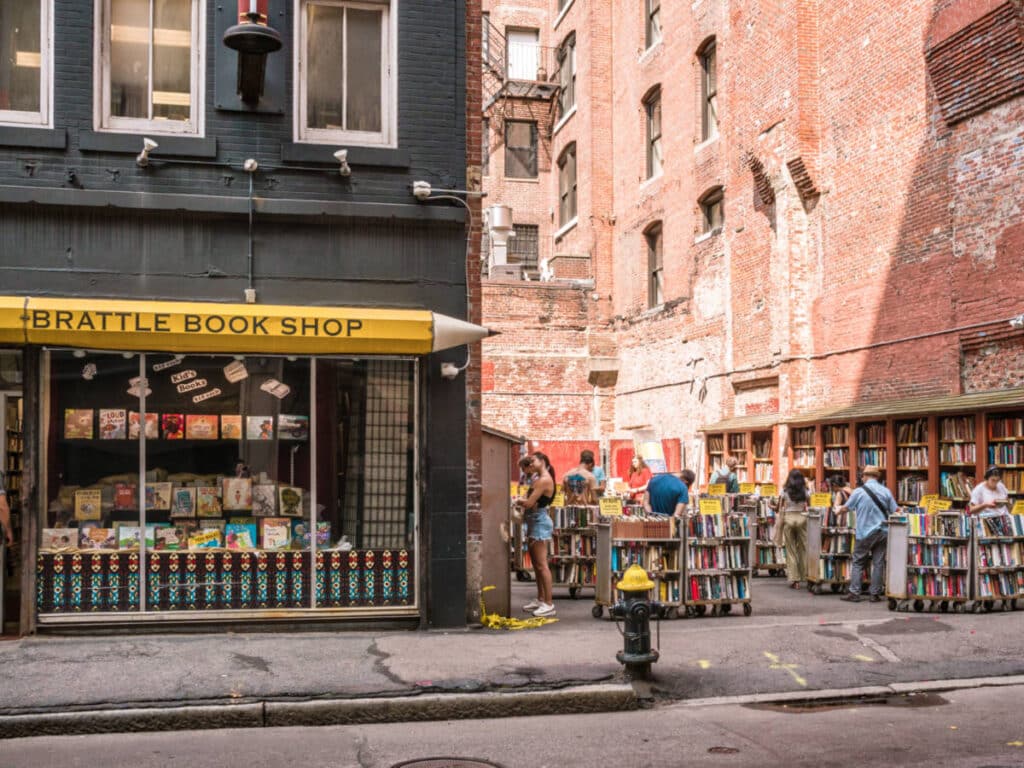 View of the people checking out the outdoor display of books in the Brattle Book Shop