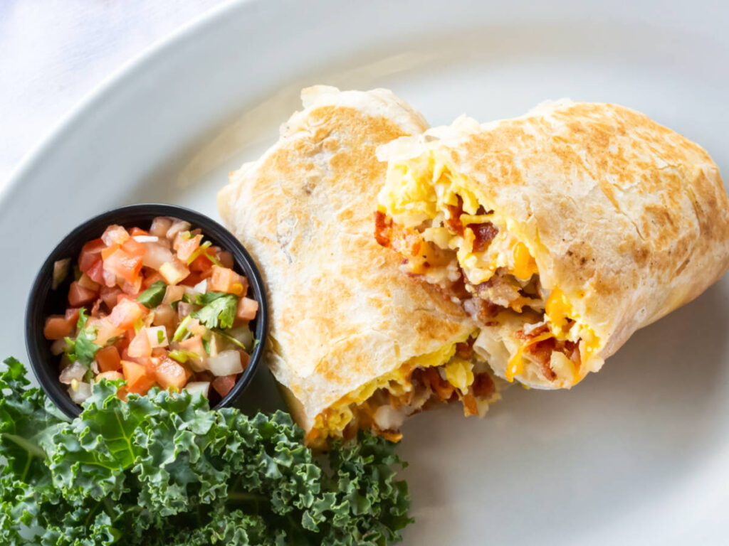 Top view of a plate with sliced breakfast burrito