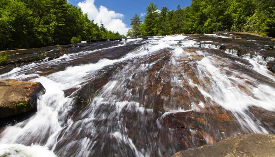 Perspective view of the Bridal Veil Falls under the clear blue sky in DuPont State Recreational Forest