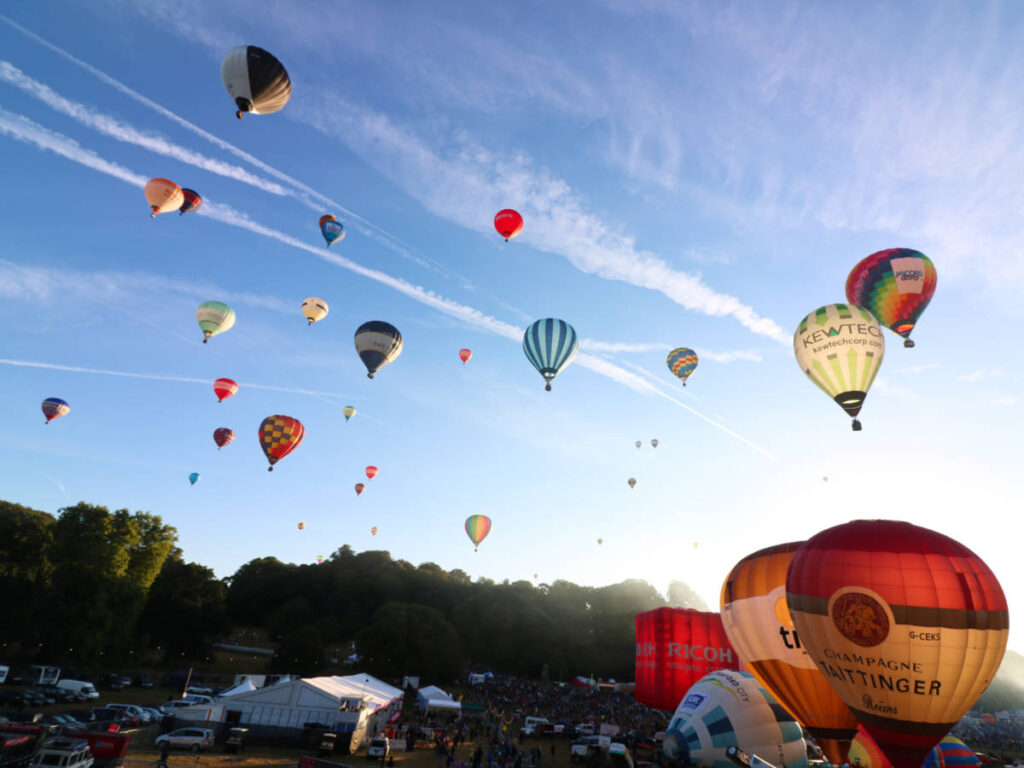 View of the launched colorful hot air balloons and the clear blue sky