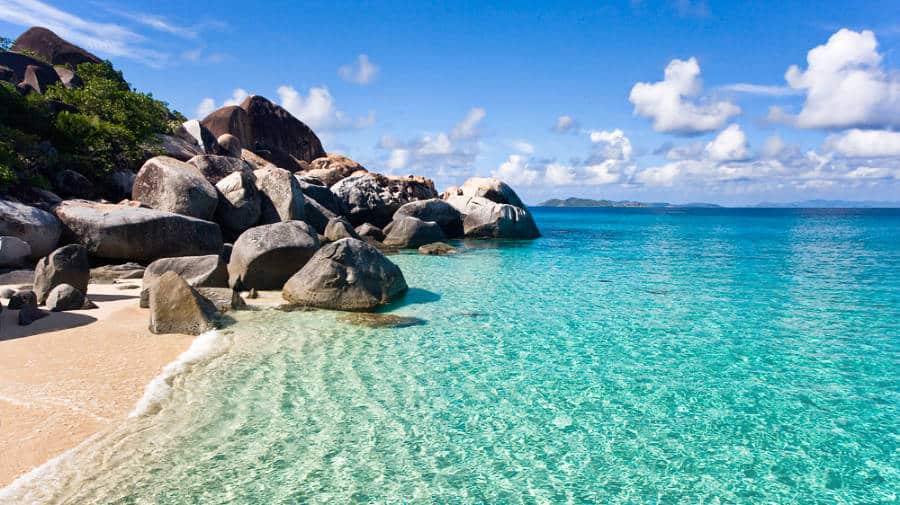 Huge rocks on the white sand and clear blue water of a tropical beach in the British Virgin Islands