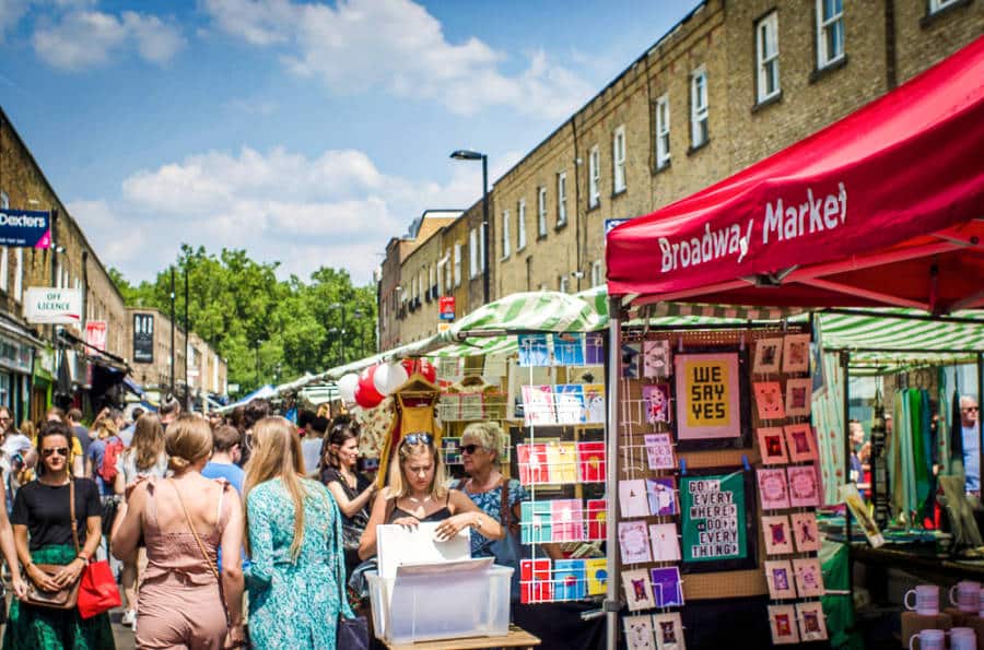 A busy shopping street of Broadway Market on a sunny day