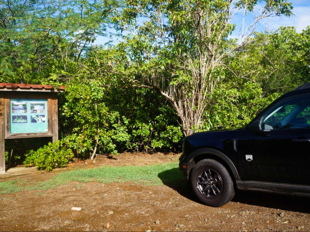 A Bronco vehicle parked near the information board
