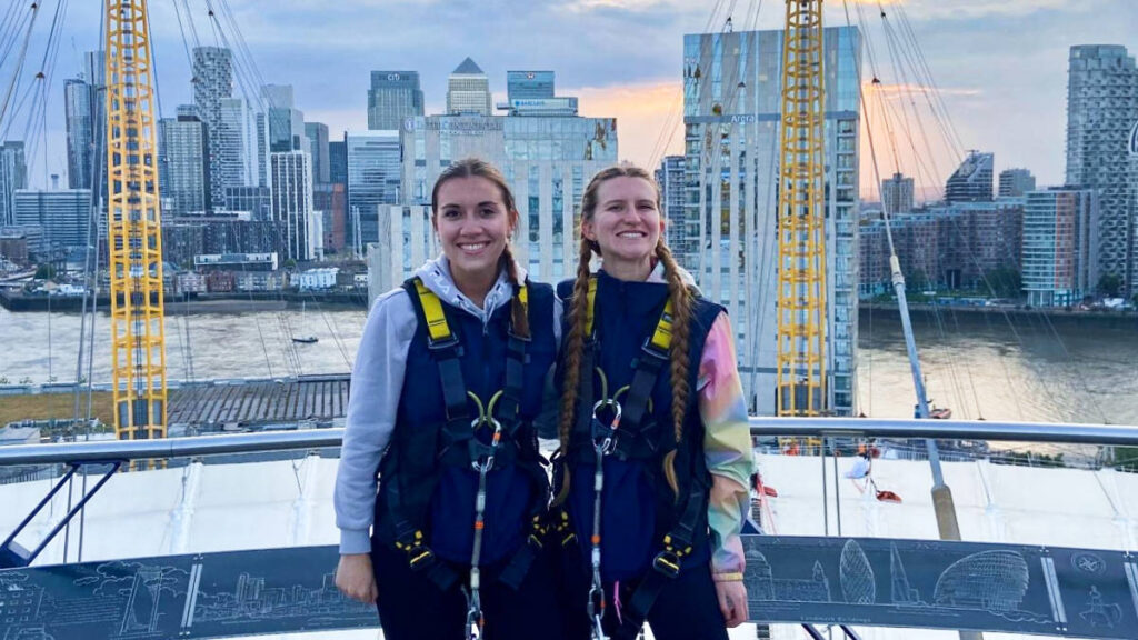 The author and her cousin posing at the Up at the O2 with the London views in the background