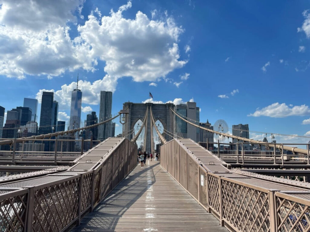 Blue sky over the people crossing the Brooklyn Bridge