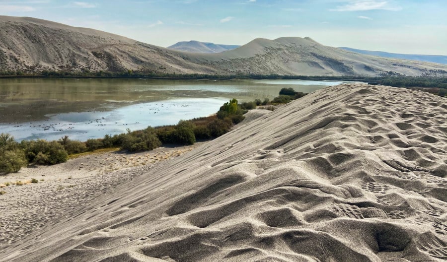 View at the top of sand dune of the scenic view of the river and mountains in Bruneau Dunes State Park