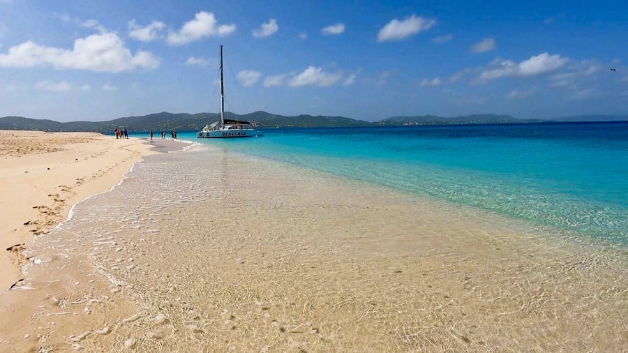 Serene view of the calm sea and people waiting for the boat in the Turtle Beach on Buck Island