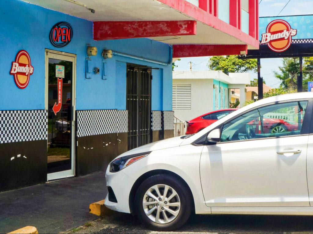 View of the cars parked outside near the entrance door of Bundy’s 